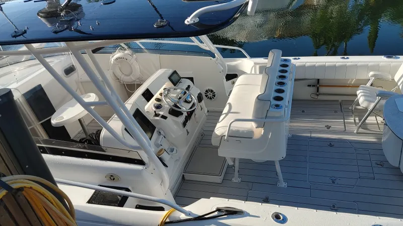Slide: The Image of 2002 Intrepid 377 Walkaround boat interior with helm, seating, and fishing rod holders. - 5