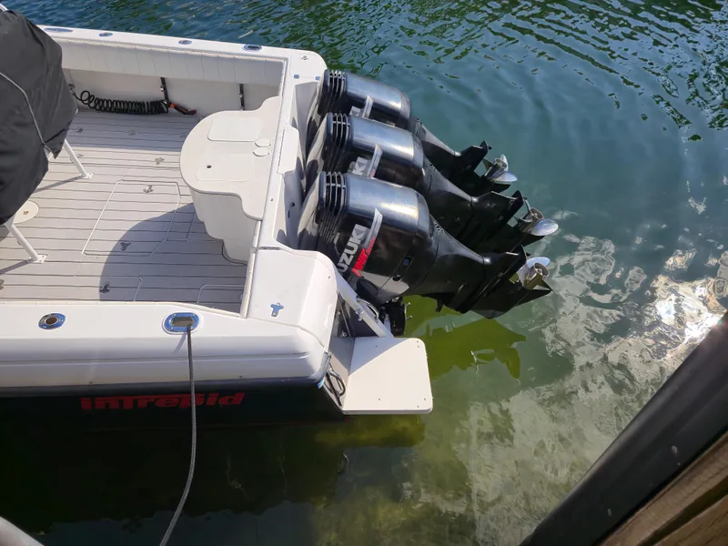 Slide: The Image of 2002 Intrepid 377 Walkaround boat with triple outboard engines in water. - 8