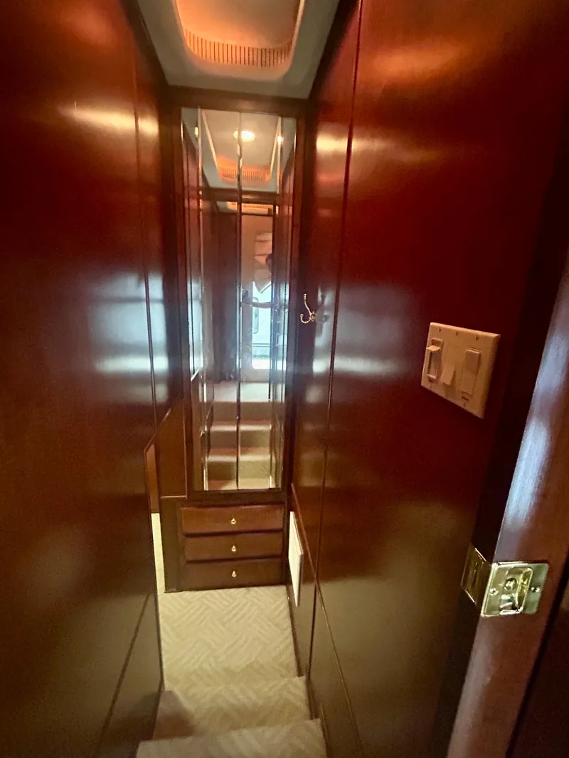 Slide: The Image of Narrow hallway inside a 2001 Fantasy houseboat with wooden walls and mirrored cabinet. - 17
