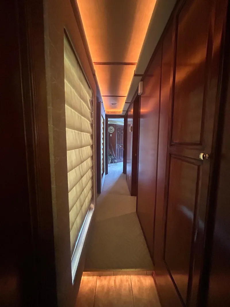 Slide: The Image of Narrow hallway inside a 2001 Fantasy houseboat, featuring warm lighting and wooden paneling. - 19