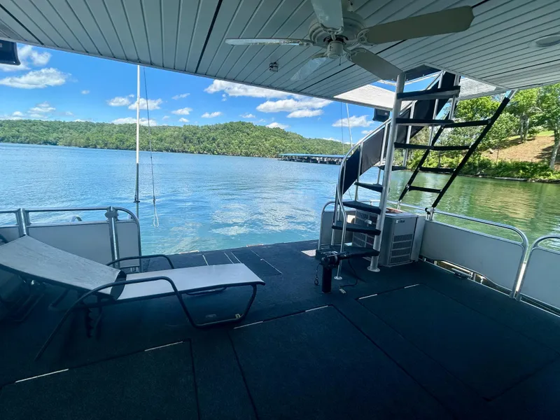Slide: The Image of Houseboat deck with lounge chair, spiral staircase, and scenic lake view under blue sky. - 26