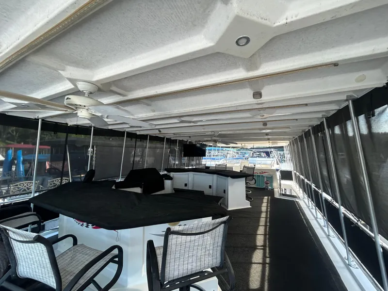 Slide: The Image of Spacious 2001 Fantasy houseboat interior with seating, ceiling fan, and covered deck area. - 28