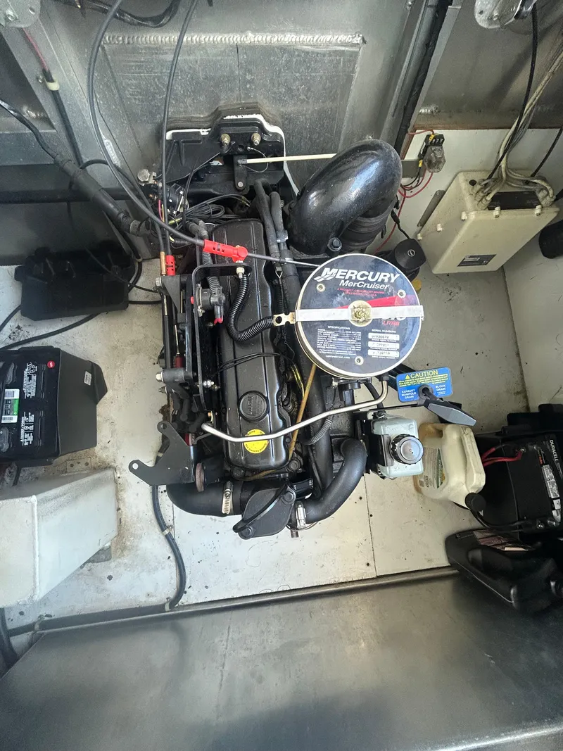 Slide: The Image of Engine of a 2001 Fantasy Houseboat, featuring a Mercury motor in a compact engine room. - 33