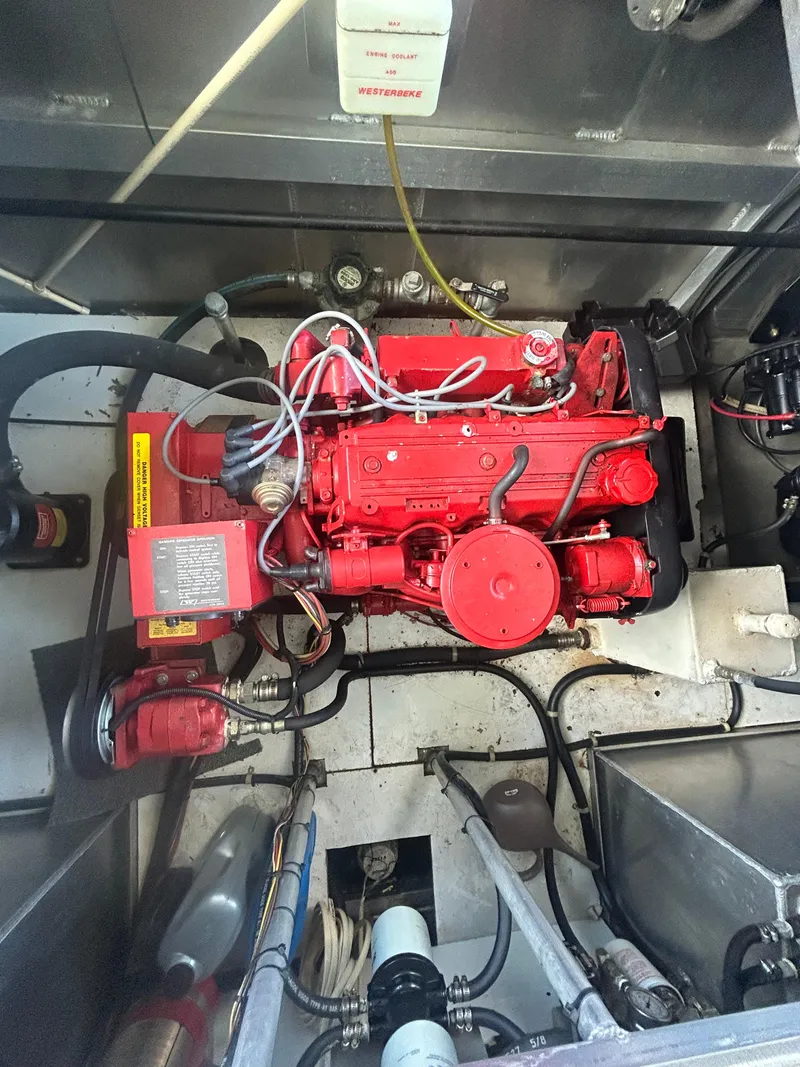 Slide: The Image of Red engine inside a 2001 Fantasy Houseboat, showcasing mechanical components and wiring. - 34