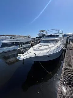The Image of 2001 Silverton 410 Sport Bridge yacht docked at marina under clear blue sky. - 0
