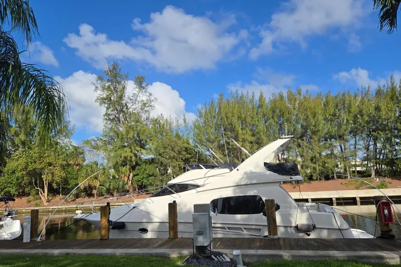 Slide: The Image of 2001 Silverton 410 Sport Bridge yacht docked under clear blue sky. - 12