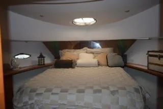 Slide: The Image of 2001 Silverton 410 Sport Bridge cabin with cozy bed and decorative accents. - 4