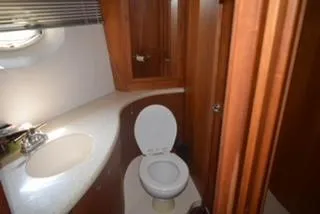 Slide: The Image of 2001 Silverton 410 Sport Bridge bathroom with wooden cabinetry and modern fixtures. - 5