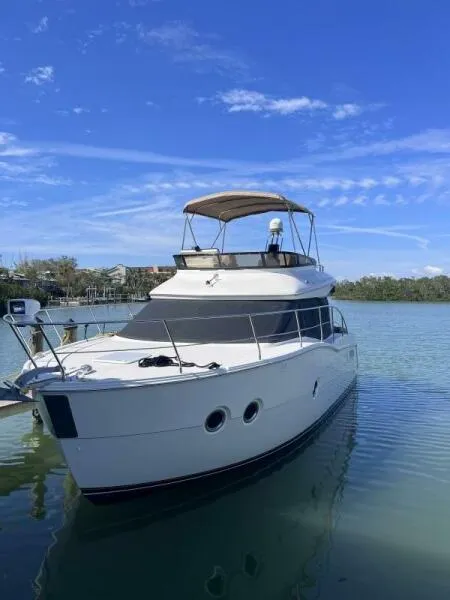 Slide: The Image of 2013 Carver C34 Command Bridge yacht on calm water under blue sky. - 1