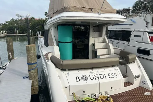 Slide: The Image of 2013 Carver C34 Command Bridge yacht docked, featuring "Boundless" name and Venice, FL location. - 2