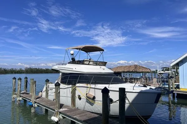 Slide: The Image of 2013 Carver C34 Command Bridge yacht docked at a marina under a clear blue sky. - 3