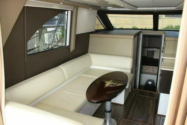 Slide: The Image of Interior of 2013 Carver C34 Command Bridge yacht with beige seating and wooden table. - 10