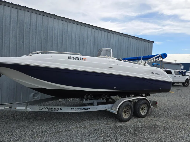 The Image of 2016 Godfrey Hurricane Sundeck SS211 Center Console boat on trailer, parked outdoors. - 0
