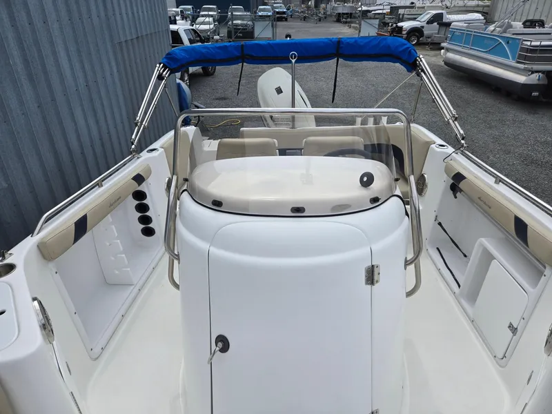 Slide: The Image of 2016 Godfrey Hurricane Sundeck SS211 Center Console boat with blue canopy, docked outdoors. - 10