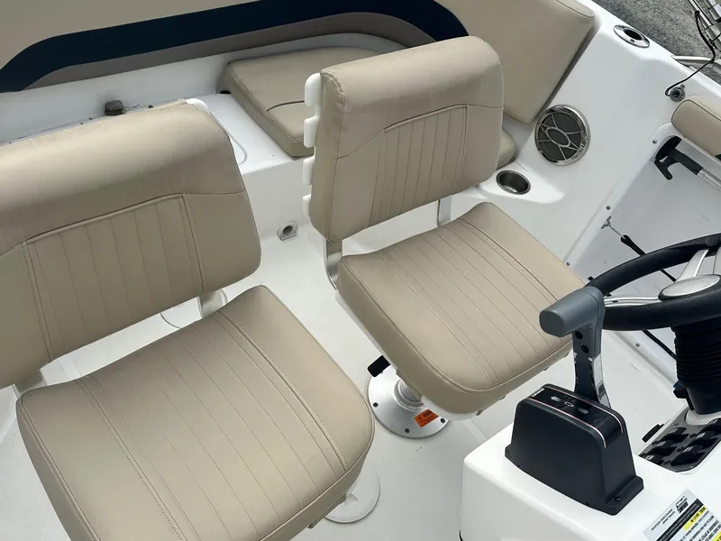 Slide: The Image of 2016 Godfrey Hurricane Sundeck SS211 Center Console with beige seating and steering console. - 16