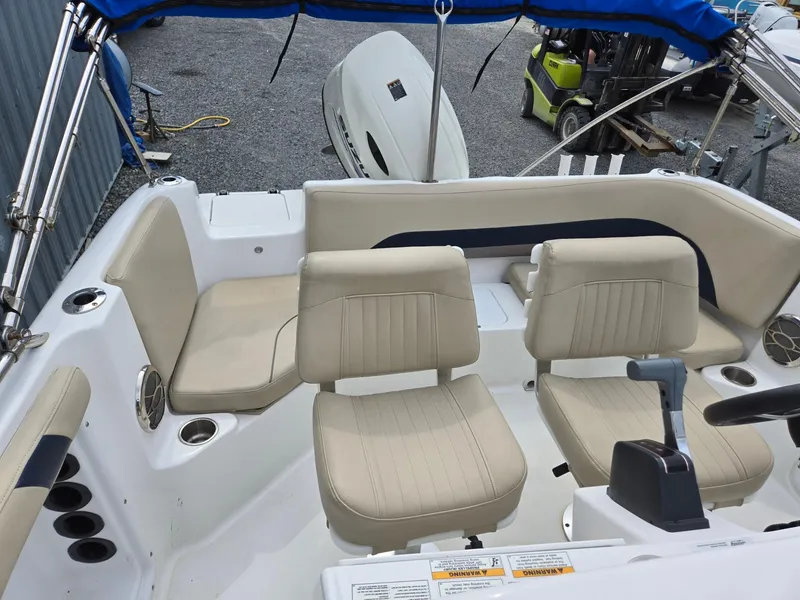 Slide: The Image of 2016 Godfrey Hurricane Sundeck SS211 Center Console with beige seating and blue canopy. - 17