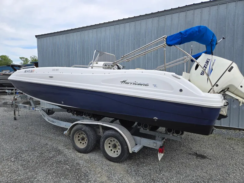 Slide: The Image of 2016 Godfrey Hurricane Sundeck SS211 Center Console boat on trailer, blue and white design. - 2
