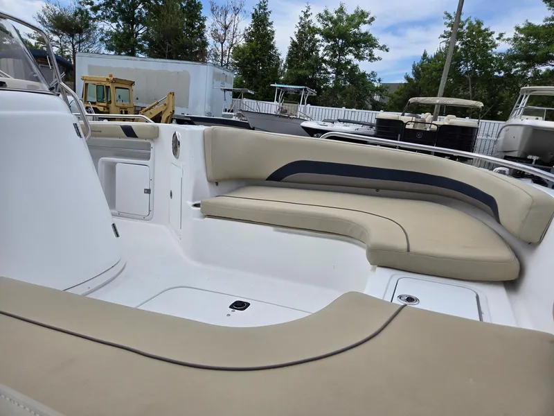 Slide: The Image of 2016 Godfrey Hurricane Sundeck SS211 Center Console with beige seating, docked outdoors. - 24