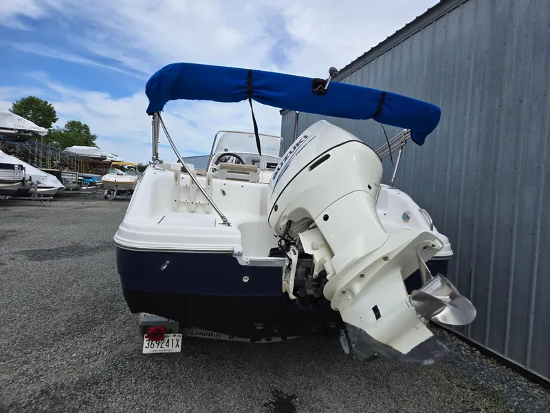 Slide: The Image of 2016 Godfrey Hurricane Sundeck SS211 Center Console boat with blue canopy and outboard motor. - 5