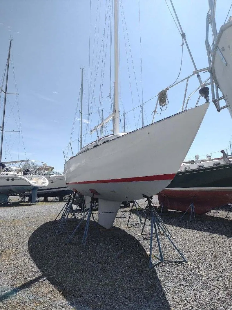 Slide: The Image of 1975 Ranger 33 sailboat on stands, displayed outdoors under clear sky. - 3