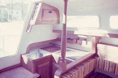 Slide: The Image of Interior of a 1975 Ranger 33 sailboat, featuring a compact kitchen and seating area. - 5