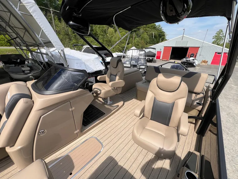 Slide: The Image of 2025 Sylvan L3 CLZ DH WT boat interior with beige seating and modern dashboard. - 11