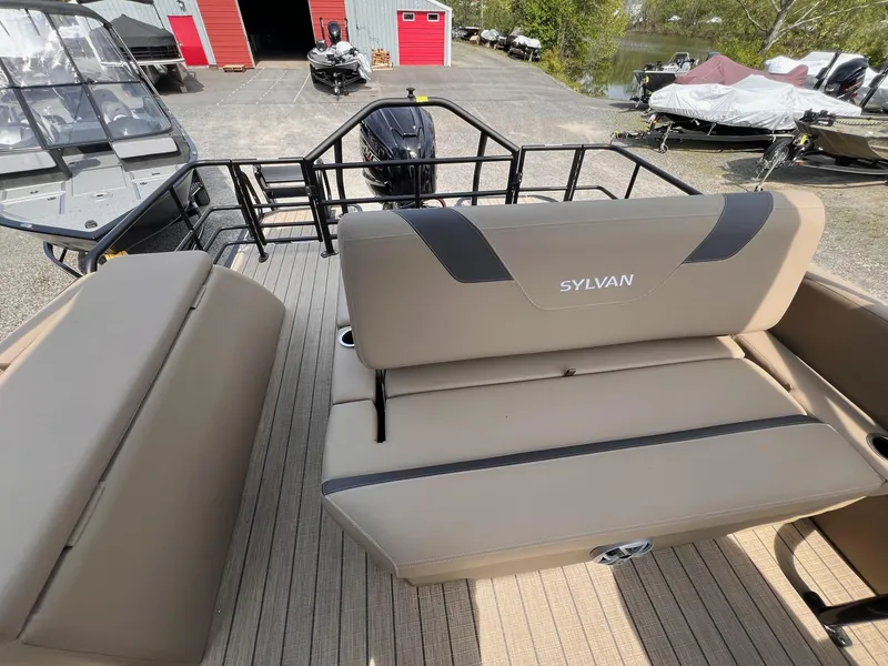Slide: The Image of 2025 Sylvan L3 CLZ DH WT boat interior with beige seating and outdoor view. - 13