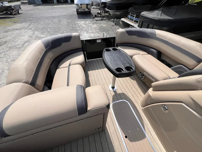 Slide: The Image of Luxurious 2025 Sylvan L3 CLZ DH WT pontoon boat interior with plush seating and table. - 34