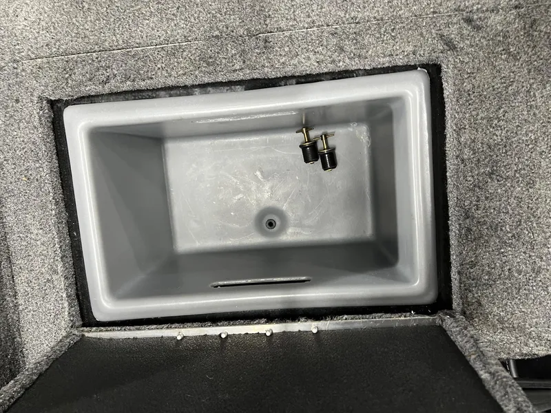 Slide: The Image of 2023 Tracker TARGA V-19 WT TE boat compartment with gray interior and two plugs. - 45