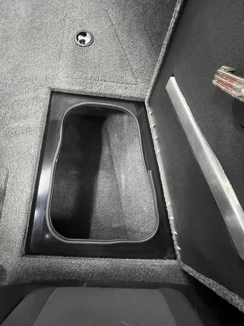 Slide: The Image of 2023 Tracker TARGA V-19 WT TE boat storage compartment, carpeted interior. - 7