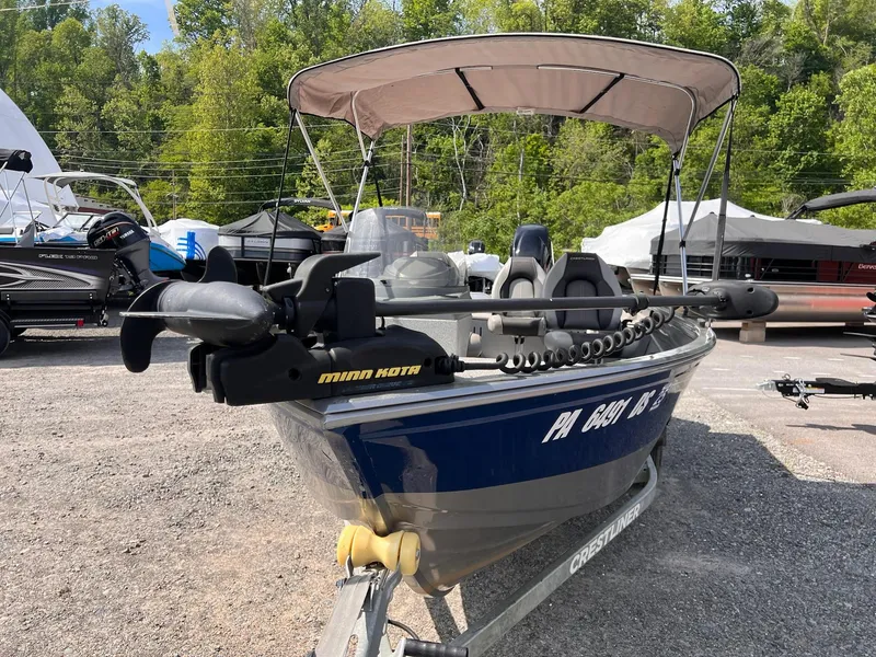 Slide: The Image of 2016 Crestliner 1650 Discovery Side Console boat with Minn Kota motor, parked outdoors. - 14