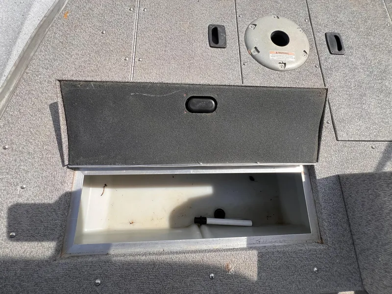 Slide: The Image of 2016 Crestliner 1650 Discovery Side Console storage compartment with open lid on boat deck. - 24