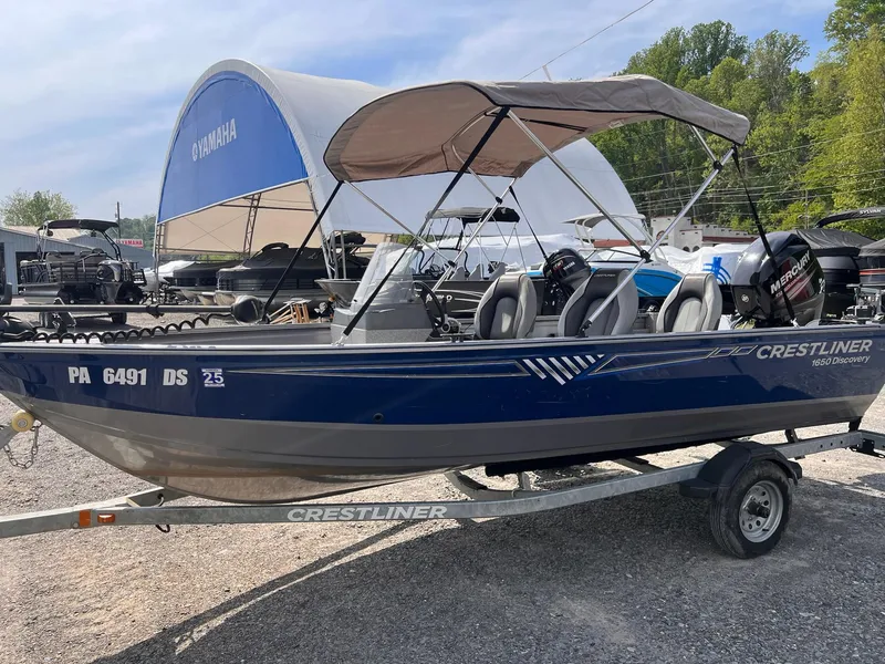 Slide: The Image of 2016 Crestliner 1650 Discovery Side Console boat on trailer, parked outdoors. - 27