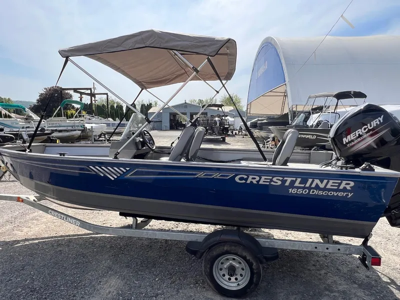 Slide: The Image of 2016 Crestliner 1650 Discovery Side Console boat with canopy and Mercury outboard motor. - 29