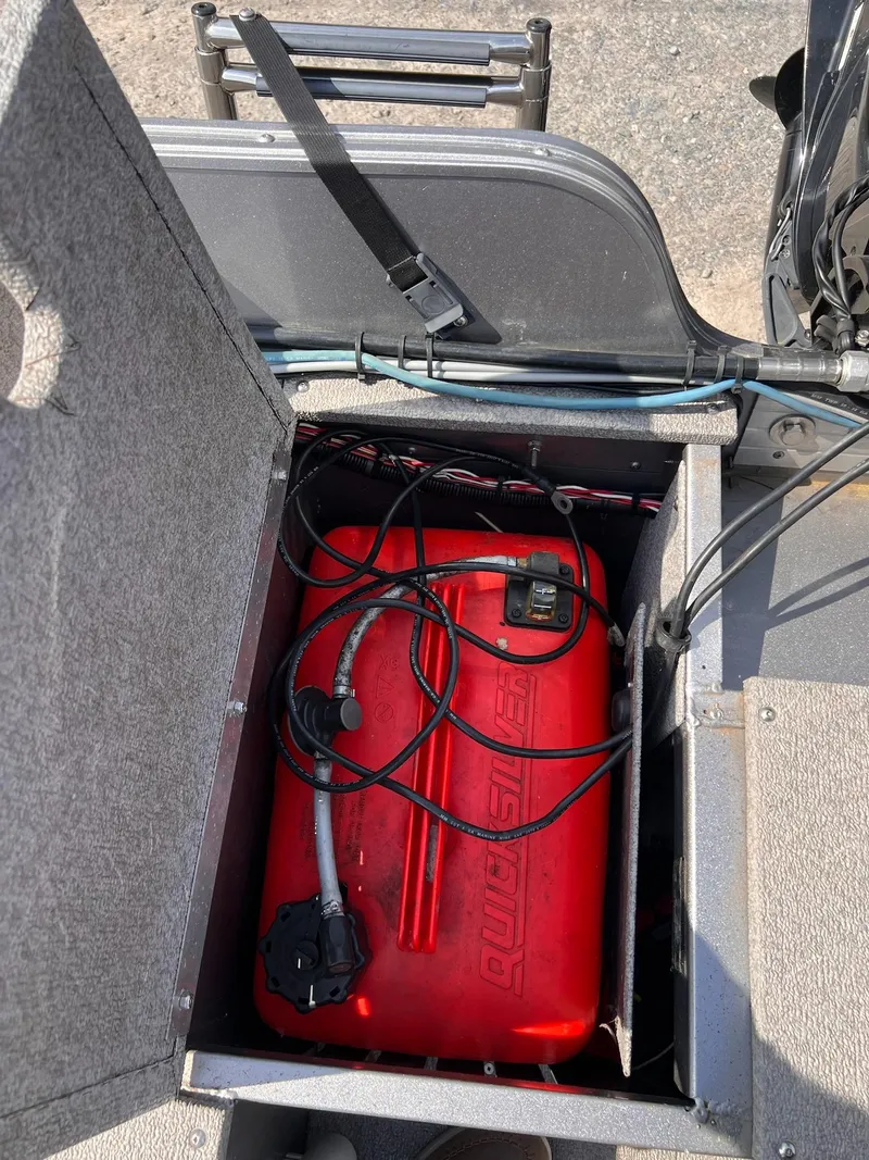 Slide: The Image of Open storage compartment with red fuel tank in 2016 Crestliner 1650 Discovery Side Console boat. - 30