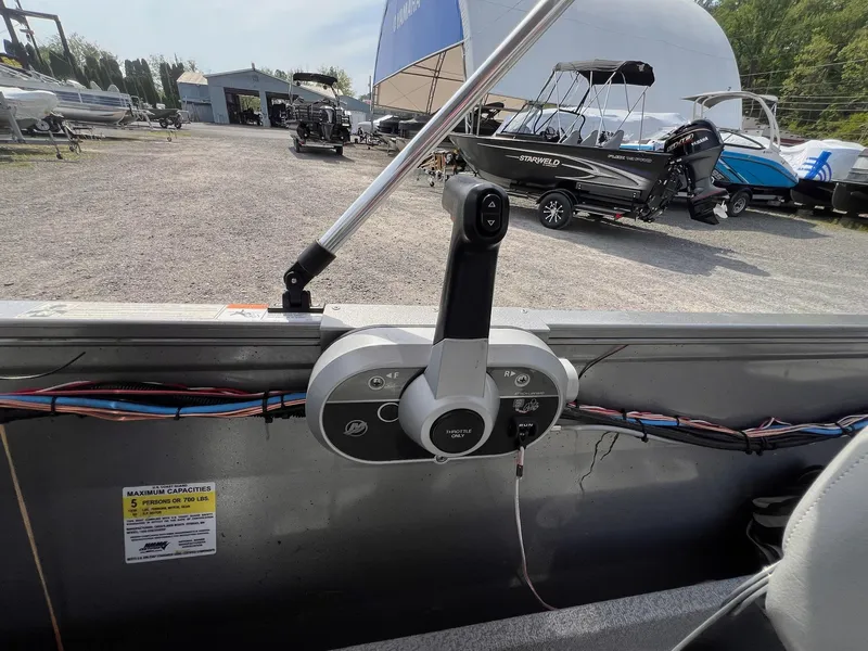 Slide: The Image of 2016 Crestliner 1650 Discovery Side Console boat throttle control in a marina setting. - 6