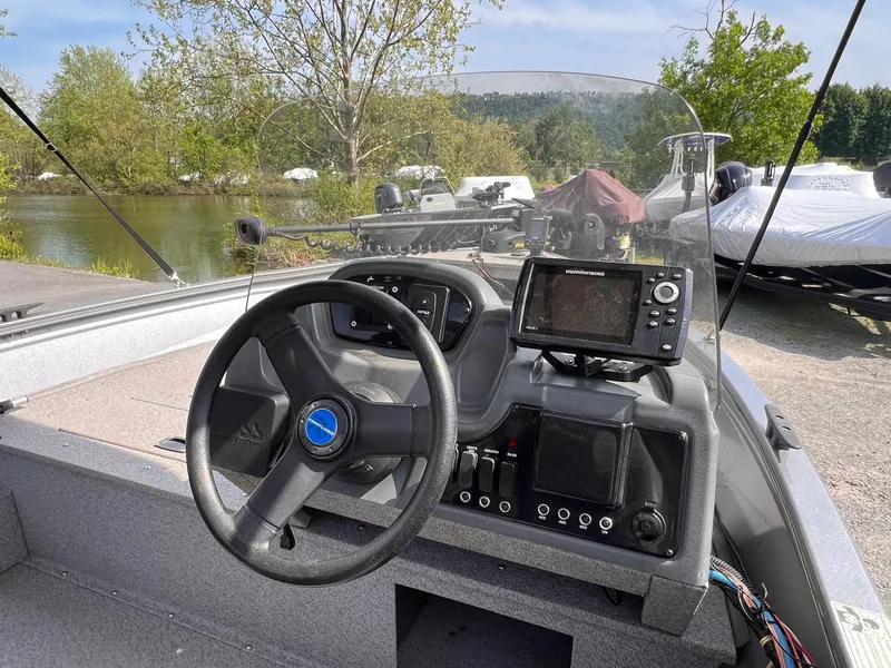 Slide: The Image of 2016 Crestliner 1650 Discovery Side Console boat interior with steering wheel and navigation equipment. - 8