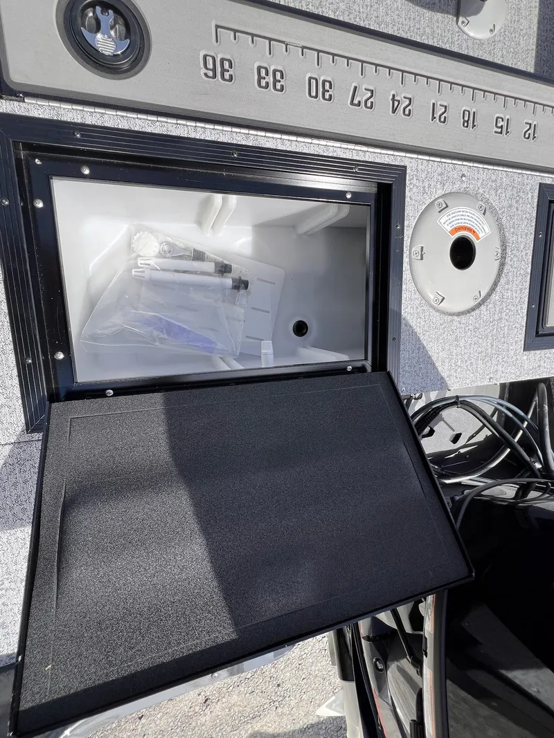 Slide: The Image of 2025 Starcraft Storm 176 DC Pro SE boat storage compartment with measuring scale and gauge. - 43