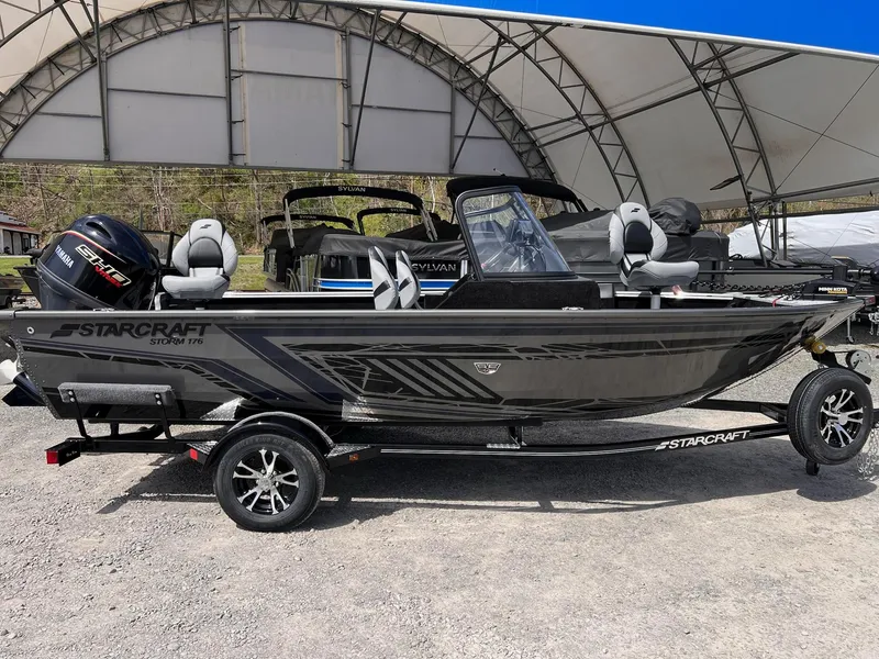 Slide: The Image of 2025 Starcraft Storm 176 DC Pro SE boat on trailer, under canopy, with Yamaha engine. - 7