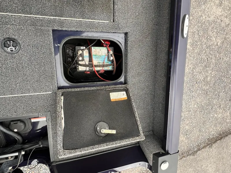 Slide: The Image of 2020 Ranger VS1782 WT boat battery compartment with visible wiring and cover. - 15