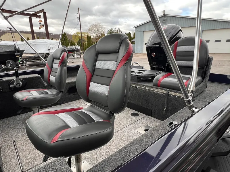 Slide: The Image of 2020 Ranger VS1782 WT boat interior with gray and red seating, parked outdoors. - 16