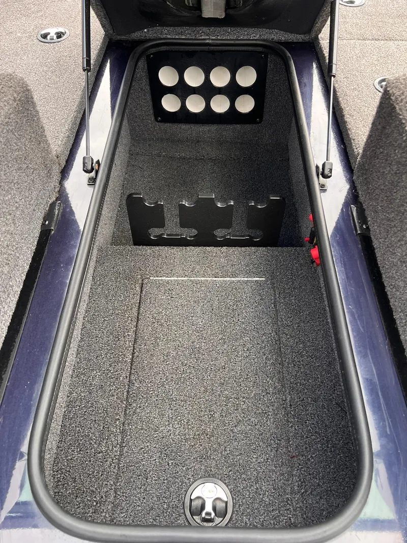 Slide: The Image of 2020 Ranger VS1782 WT boat storage compartment with rod holders and carpeted interior. - 37