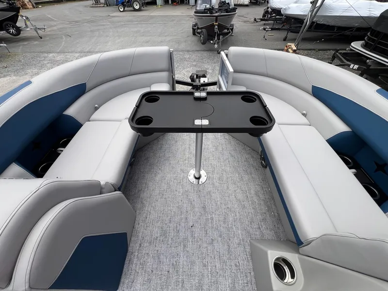 Slide: The Image of 2025 Berkshire LE Series 24UL LE pontoon boat interior with gray and blue seating and table. - 16