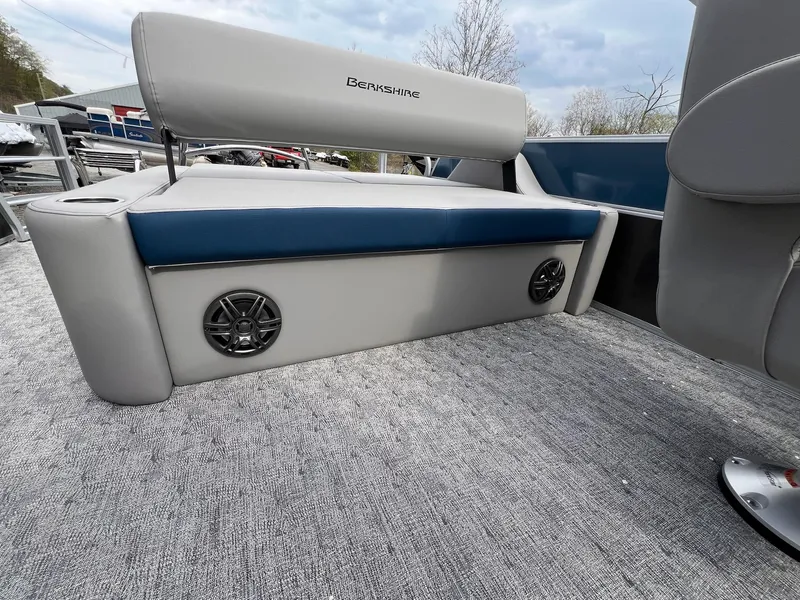 Slide: The Image of 2025 Berkshire LE Series 24UL LE boat interior with cushioned seating and built-in speakers. - 24