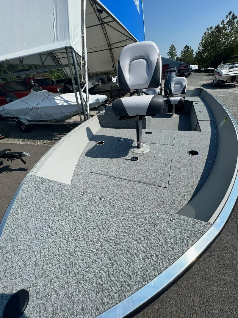 Slide: The Image of 2024 Starcraft Patriot 16 SC boat with seating, displayed outdoors under a canopy. - 12