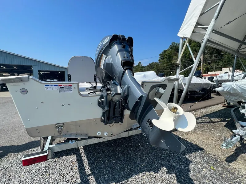 Slide: The Image of 2024 Starcraft Patriot 16 SC boat with outboard motor, displayed outdoors. - 14