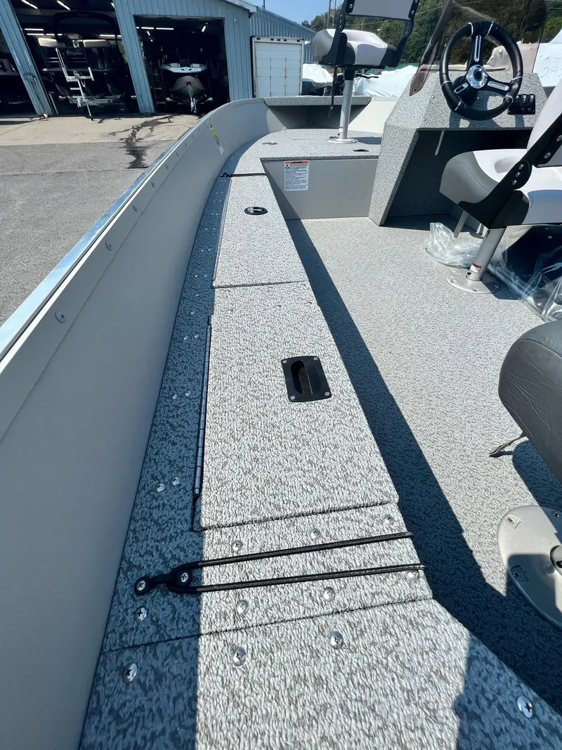 Slide: The Image of 2024 Starcraft Patriot 16 SC boat interior with steering wheel and seating. - 17