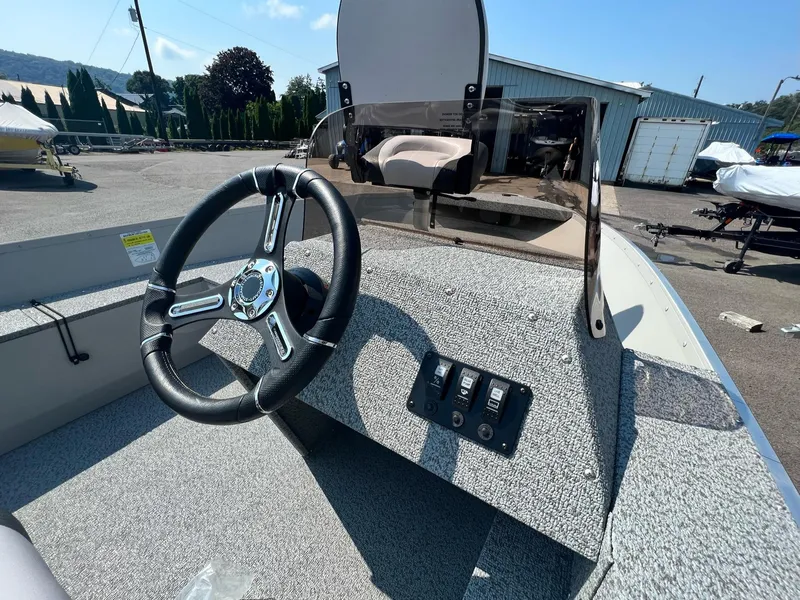 Slide: The Image of 2024 Starcraft Patriot 16 SC boat dashboard with steering wheel and controls. - 6