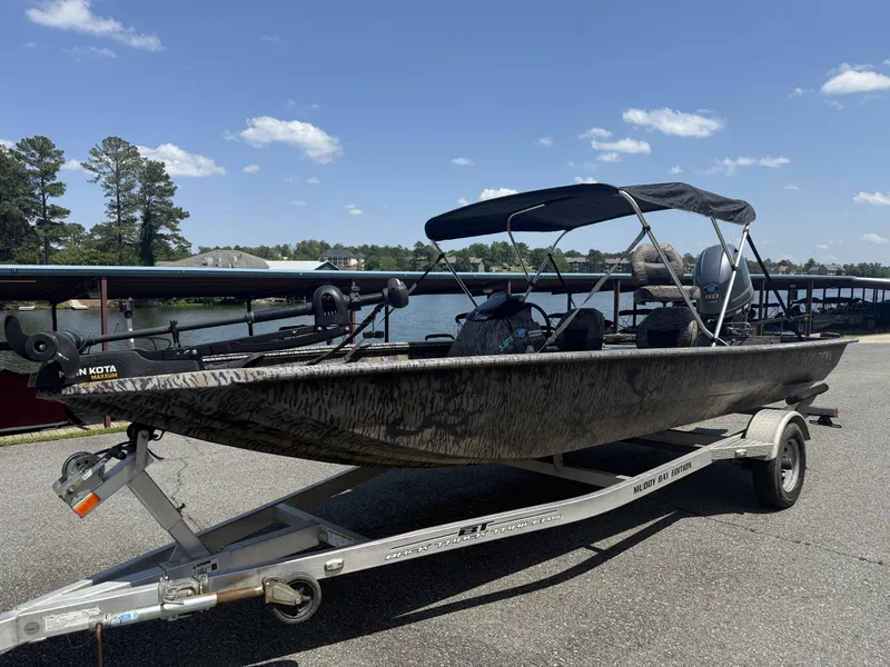 Slide: The Image of 2018 Xpress Xplorer Series XP180 boat on trailer by a lake under clear sky. - 3