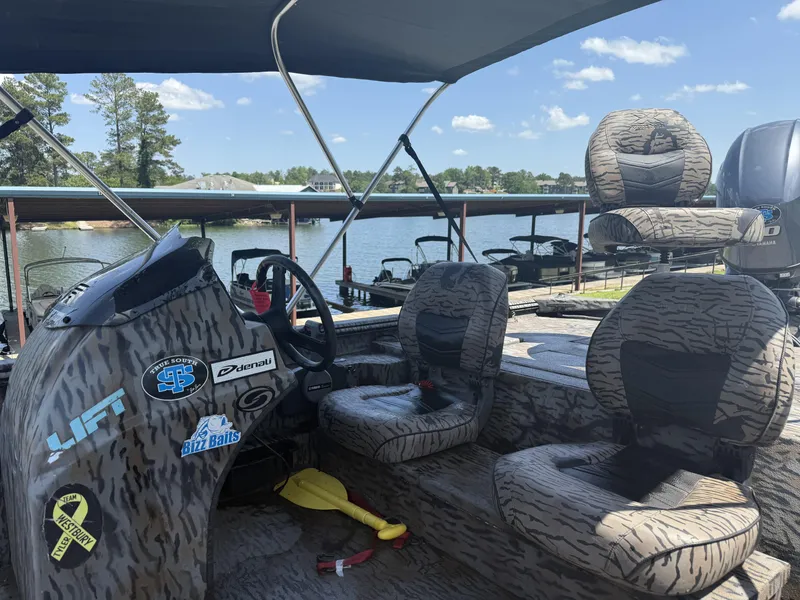 Slide: The Image of 2018 Xpress Xplorer Series XP180 boat with camo seats, docked by a scenic lake. - 8